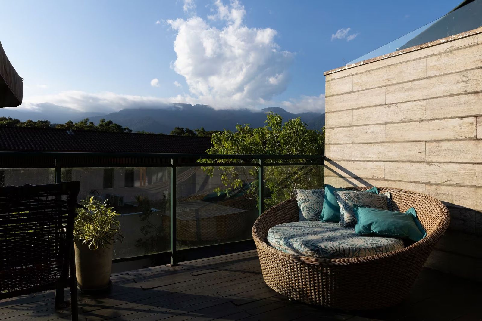 Terraço com sofá de vime e vista para a serra da Mata Atlântica