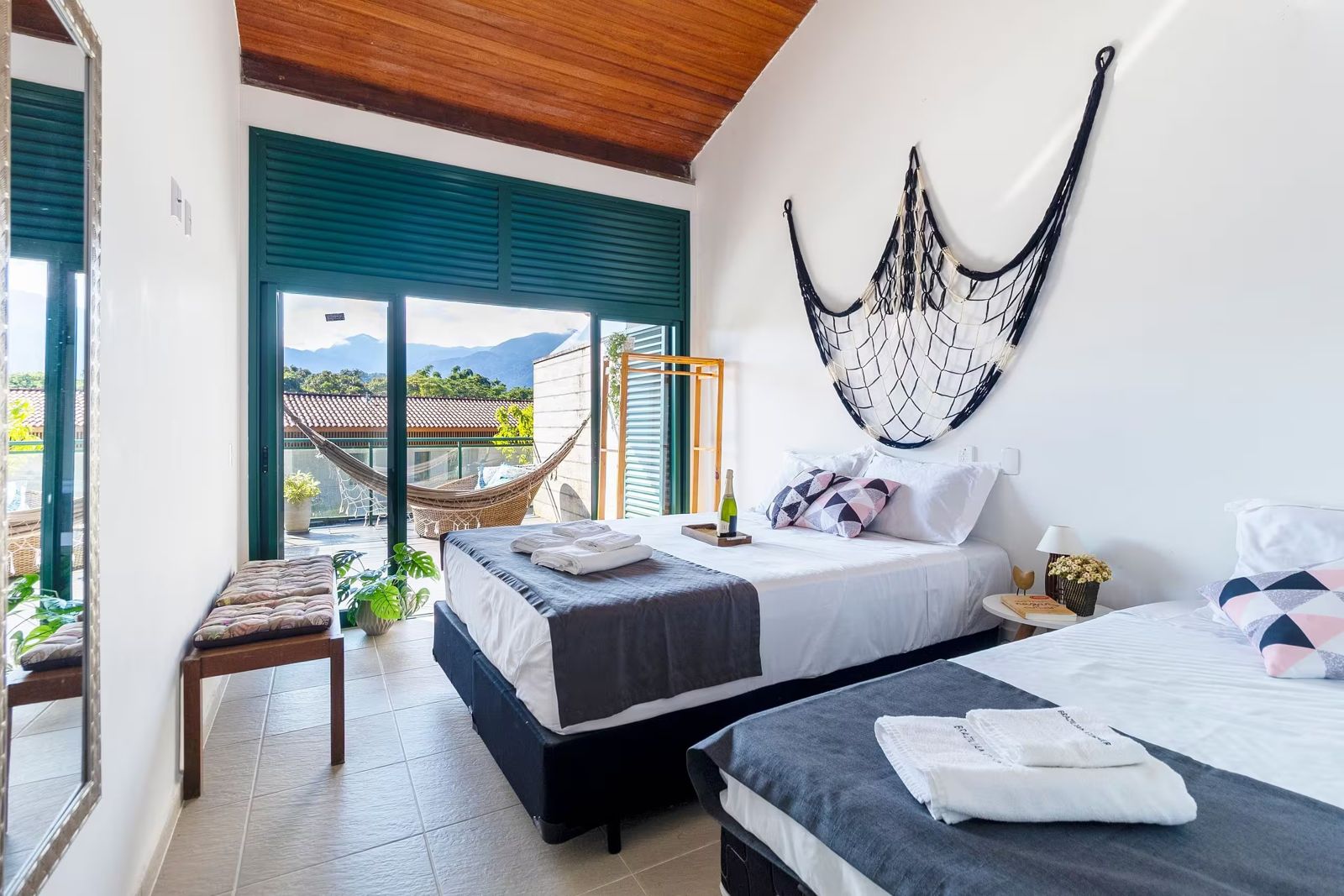 Quarto com rede decorativa e portas para a varanda