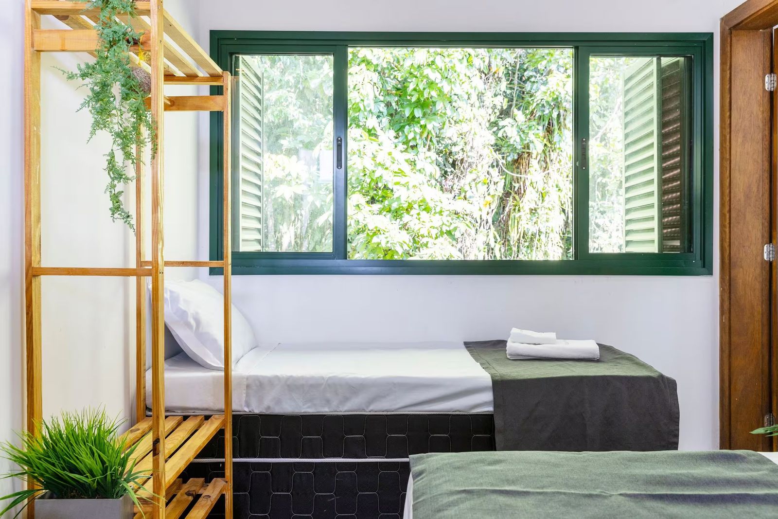 Quarto com janela verde para a mata