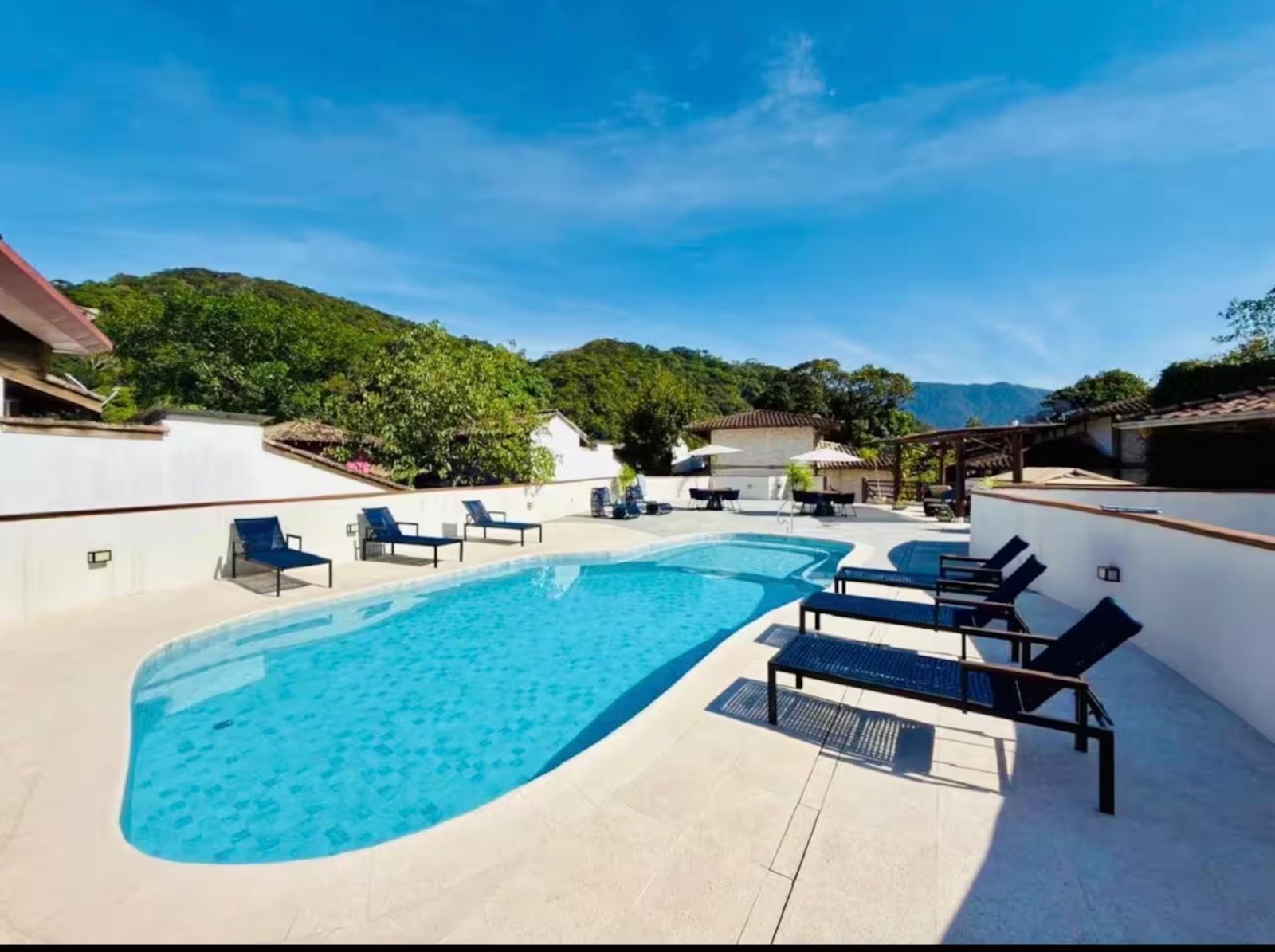 Piscina do condomínio do Flat Camburi com a serra ao fundo