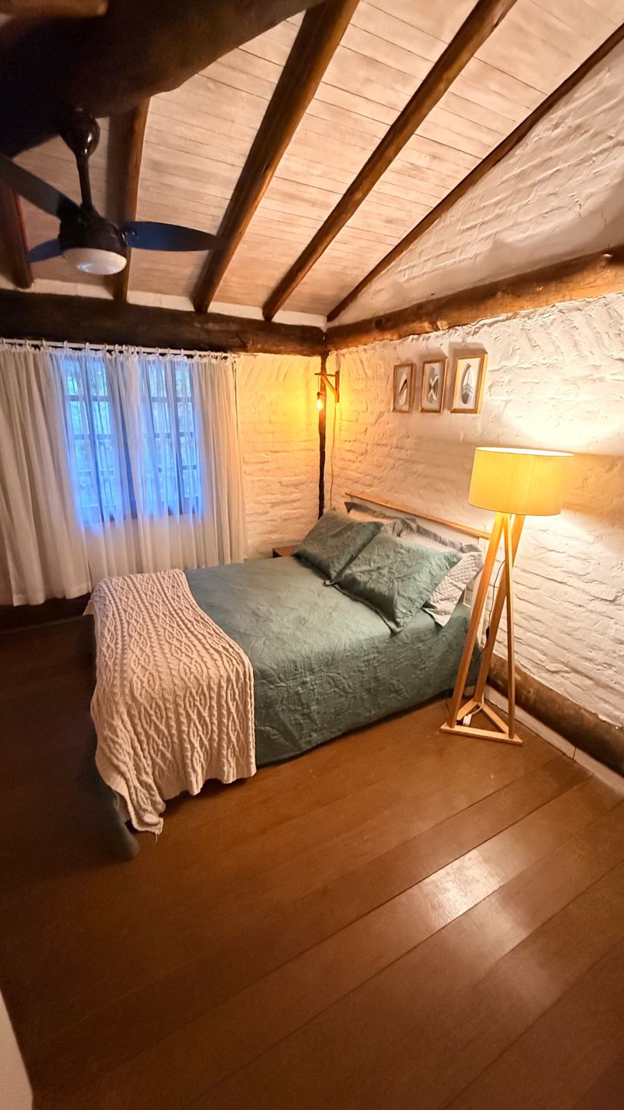 Quarto com cama de casal e luminária de pé