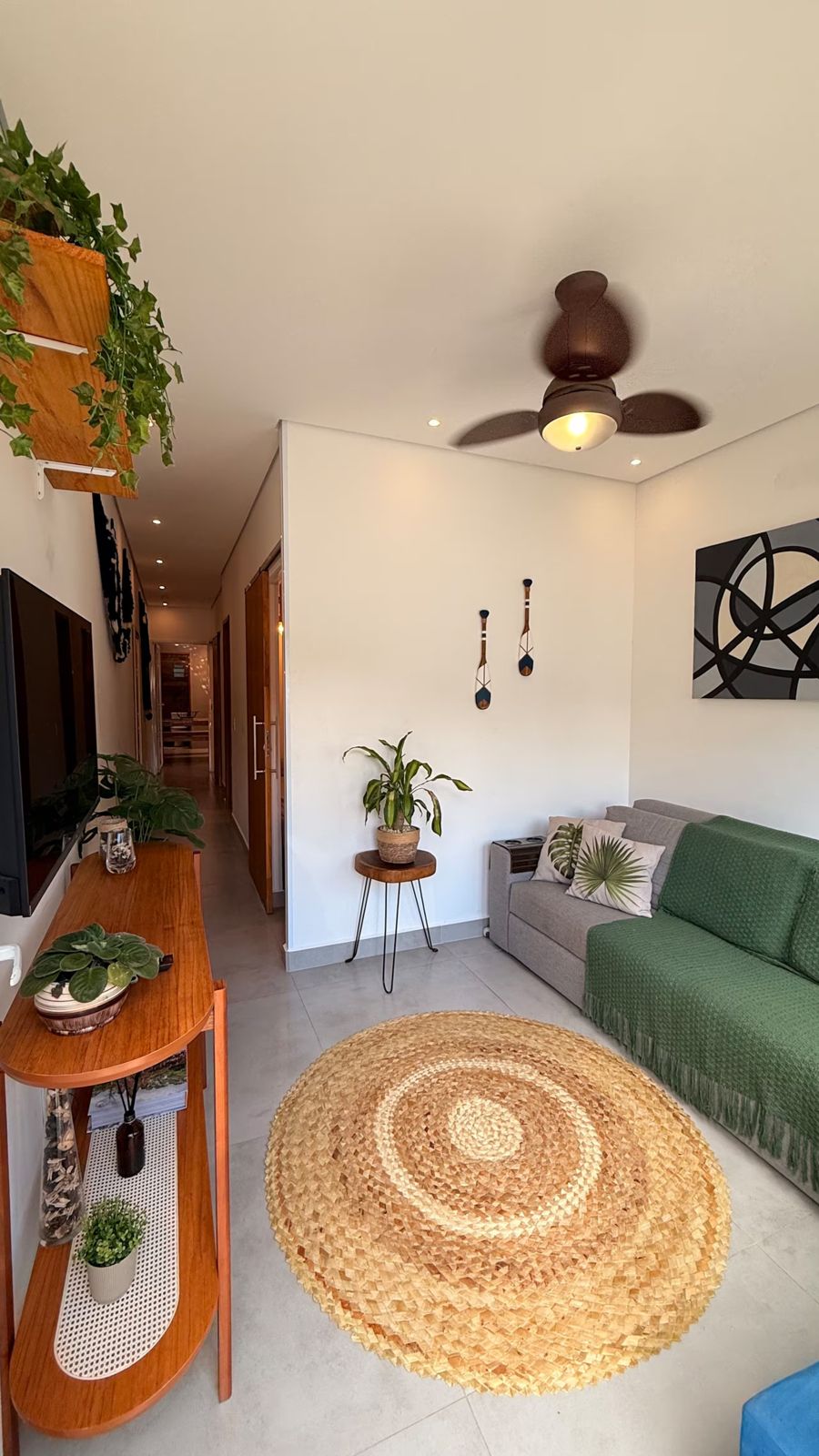 Sala com sofá, aparador e ventilador de teto