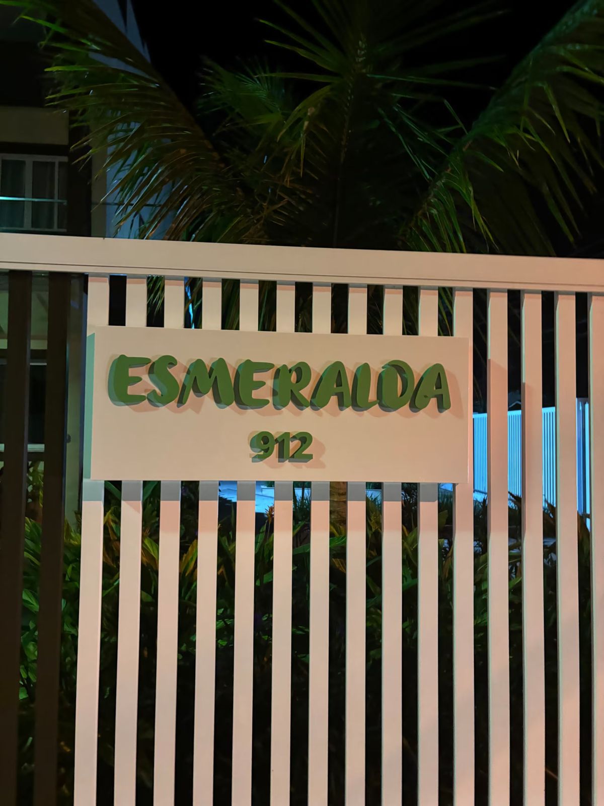 Entrada do condomínio com a placa iluminada