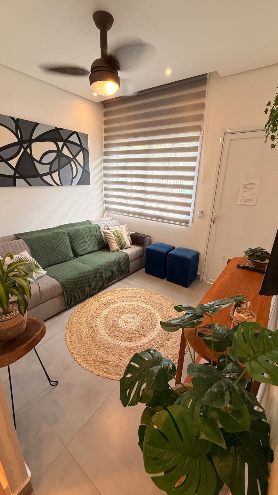 Sala com sofá verde e plantas
