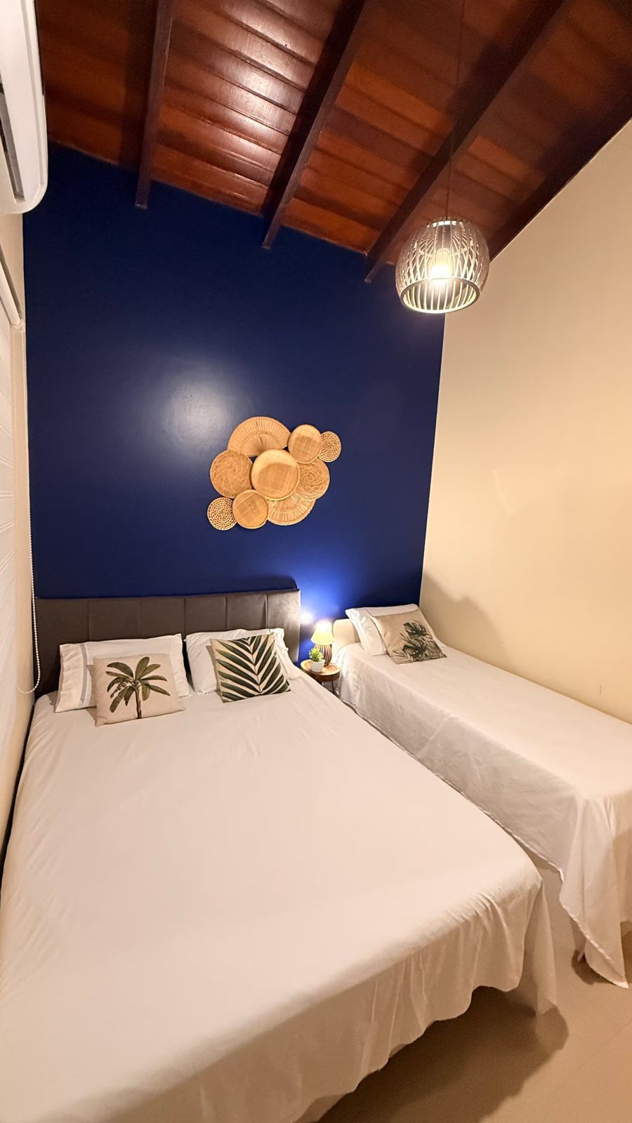 Quarto com parede azul e duas camas
