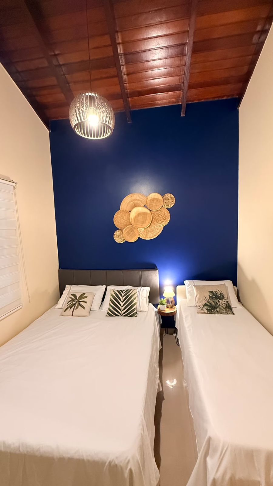 Camas com enxoval branco e luminária