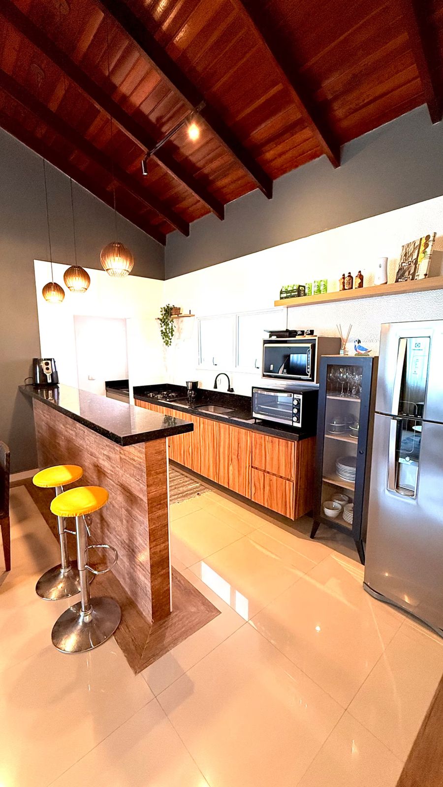 Cozinha americana com banquetas amarelas