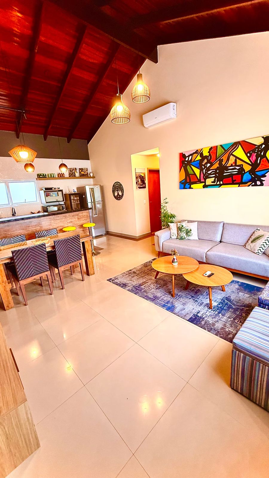 Sala de estar com sofá, tapete e quadro colorido