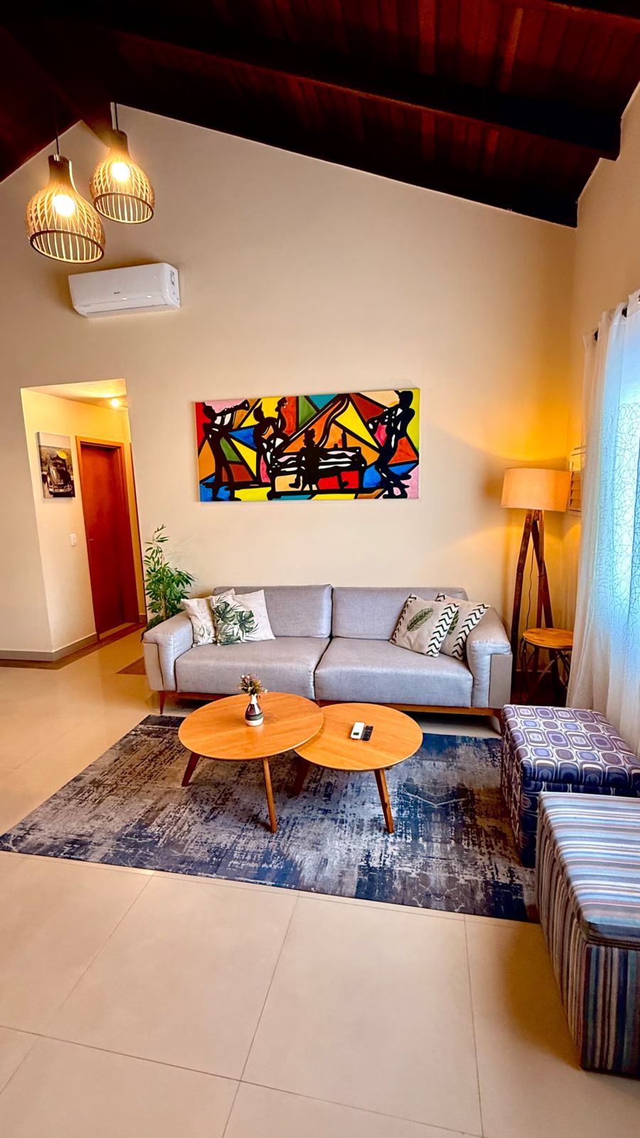Sala com sofá cinza e mesas de centro redondas
